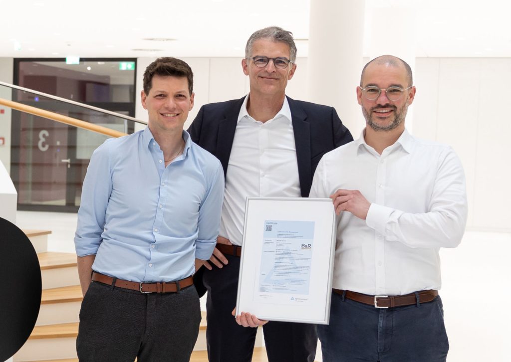 CTO Florian Schneeberger (Mitte) sowie Robert Fuchs (rechts) und Gregor Auer (links) vom Cyber-Security-Team präsentieren das Zertifikat. 